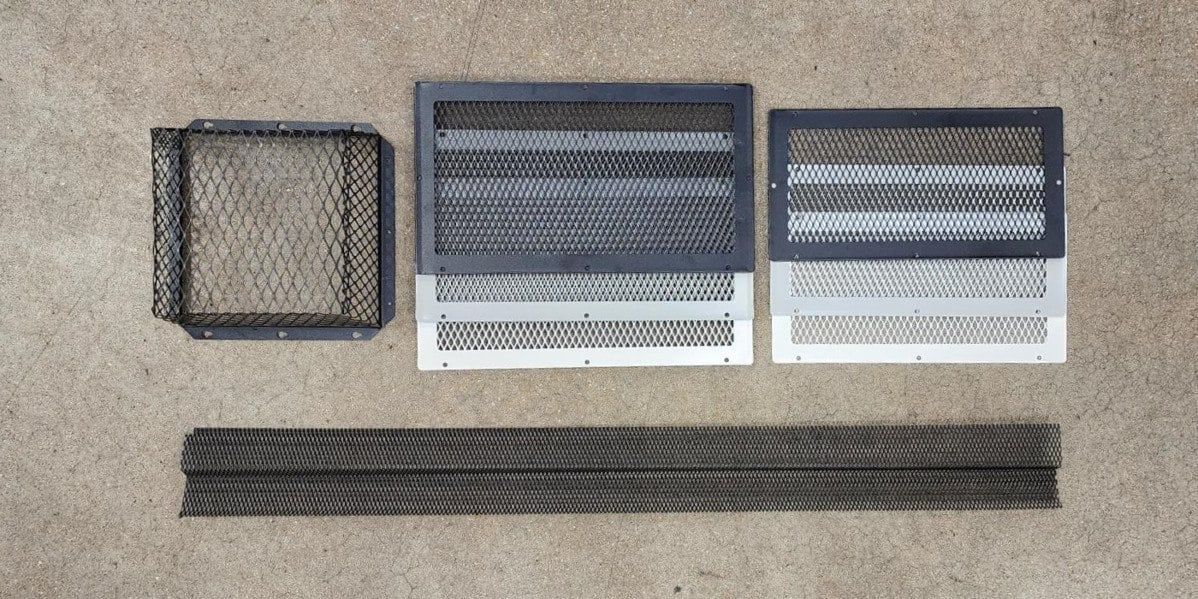 From left to right: a black HY-GUARD EXCLUSION Roof Vent Guard, three stacked foundation vent guards with Insect Armor, three stacked soffit vent guards with Insect Armor, and a strip of Stainless Steel Pest Armor Ultimate all laying on a concrete floor.