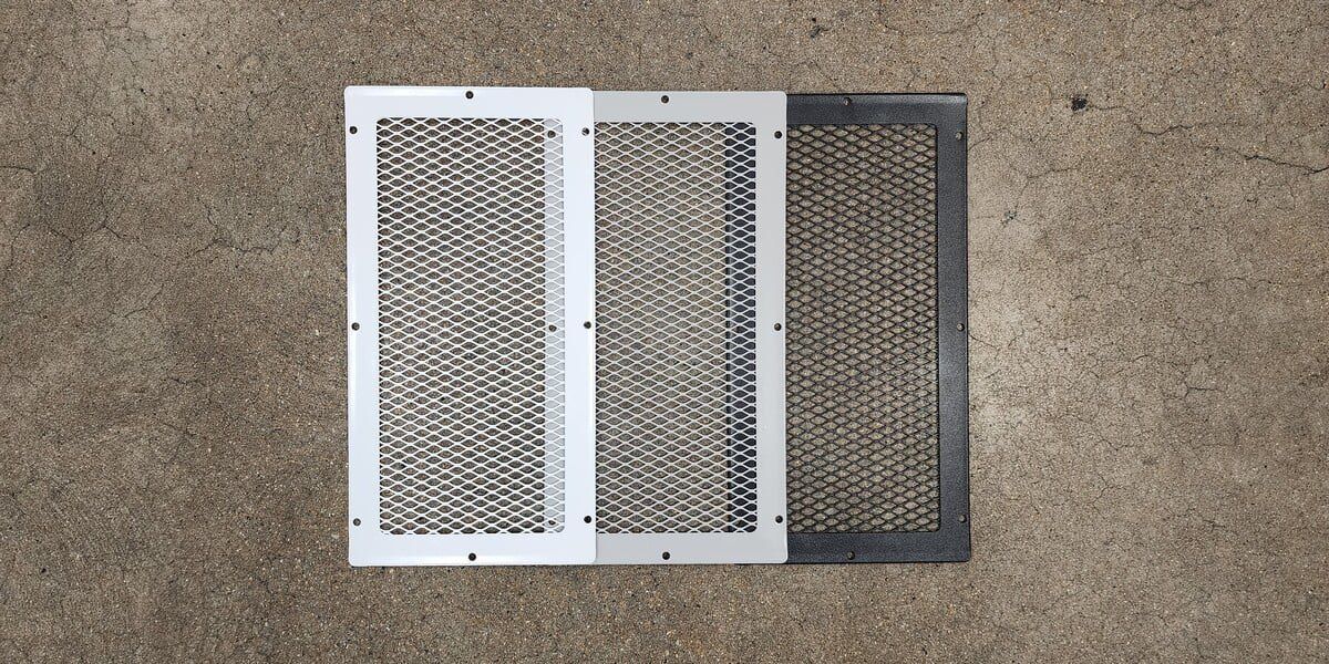 A white, gray, and black HY-GUARD EXCLUSION 8" x 16" foundation vent guard laying side by side on a concrete floor