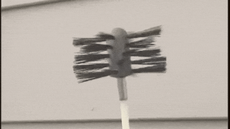 A GIF of the LintEater rotary dryer vent cleaning tool snaking its way through a transparent dryer vent