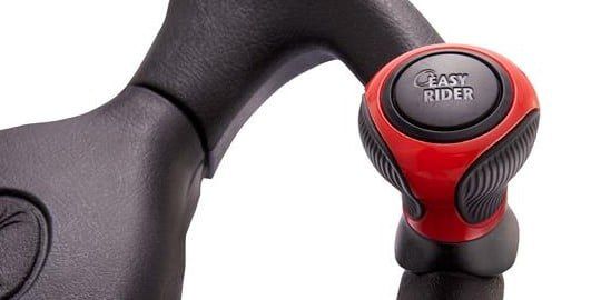 A red Good Vibrations Easy-Rider Tight-Turn Steering Knob installed on a steering wheel against a white background