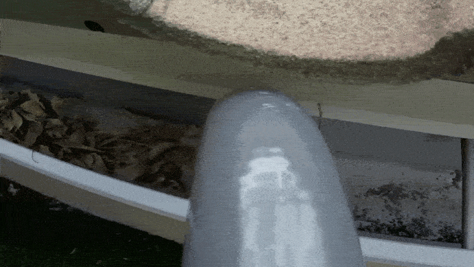 A POV GIF of a Gutter Clutter Buster sucking leaves out of a gutter.