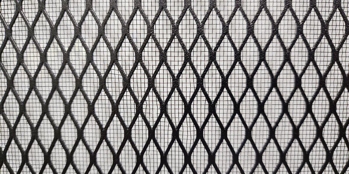 A close-up of a screen with diamond mesh inlaid with stainless steel bug mesh against a white background