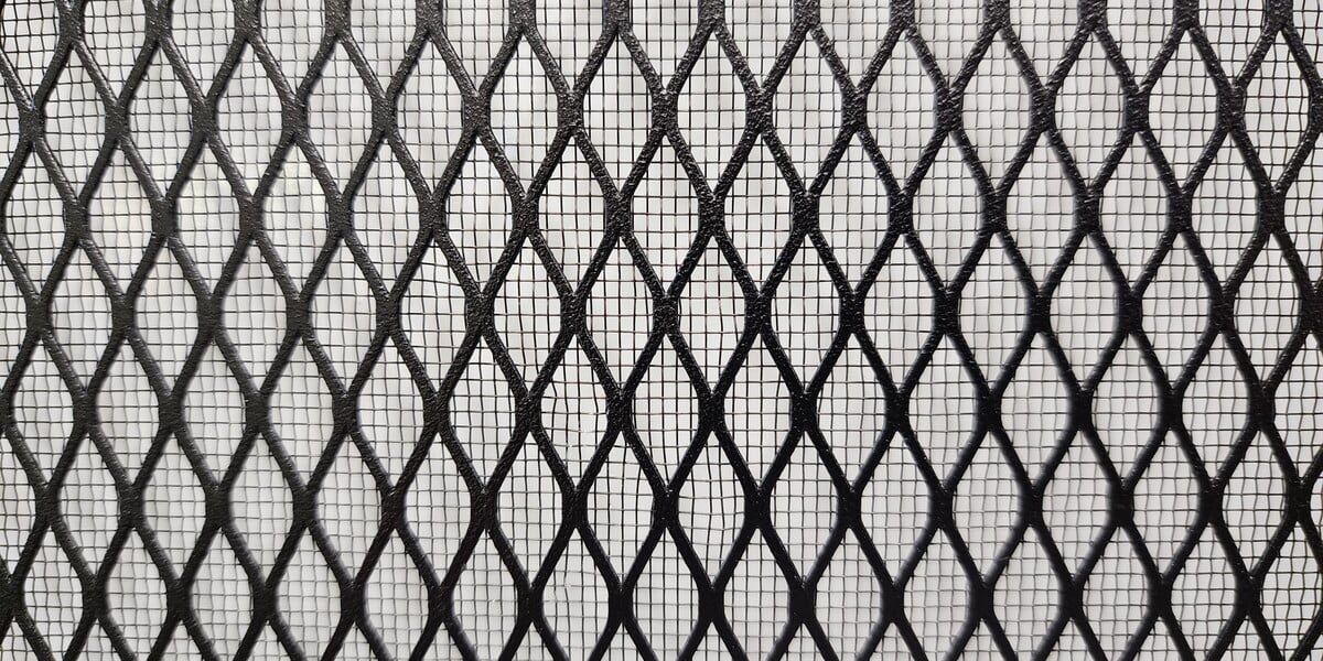 A close-up of a screen with diamond mesh inlaid with stainless steel bug mesh against a white background