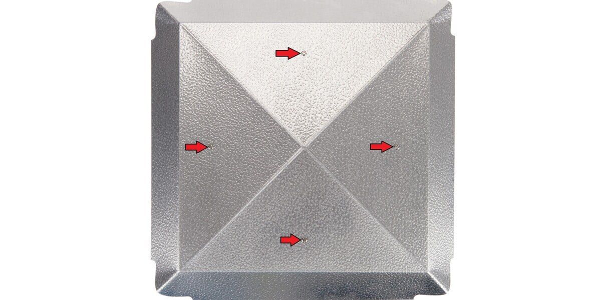 A top-down view of the cover of a multi-fit chimney cap with four red arrows indicating the position of the bolt attachment points