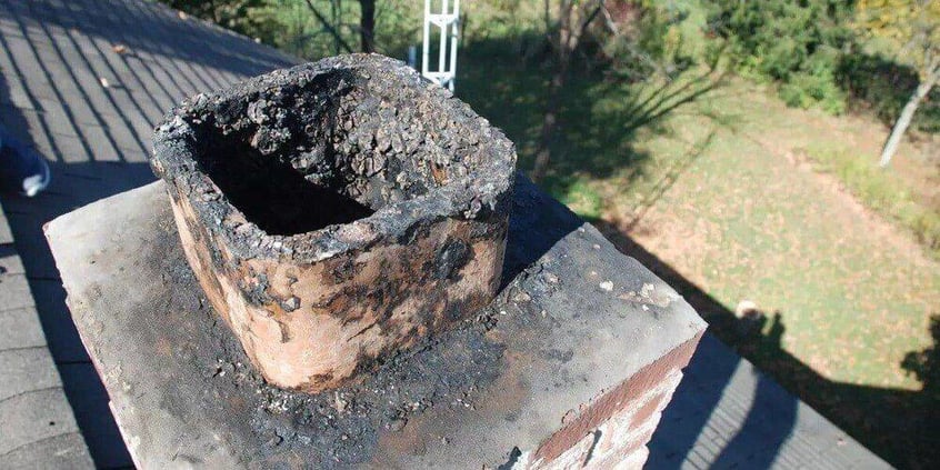 An uncapped chimney flue filled with creosote buildup.