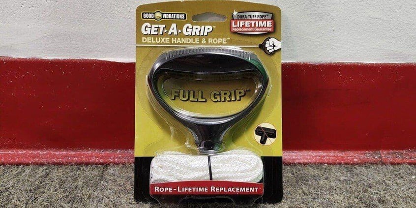A Good Vibrations Get-A-Grip replacement pull cord handle in its retail packaging leaning against a wall.