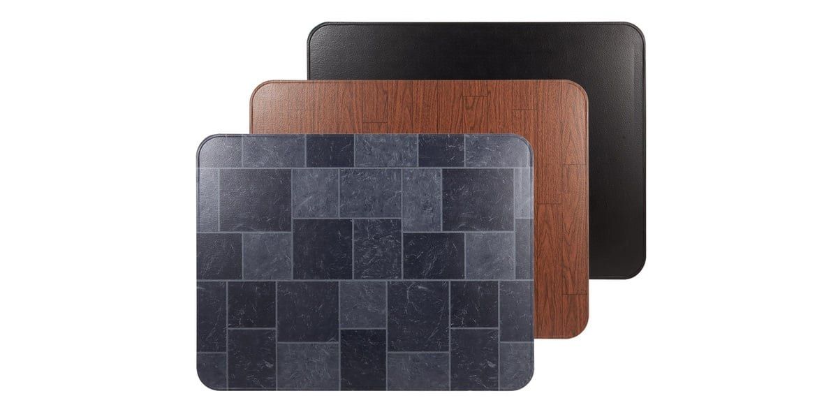 A gray slate stove board, a wood grain stove board, and a black stove board stacked on each other and staggered against a white background