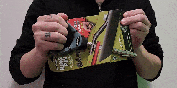 A person opening and closing the butterfly-style locking mechanism of a Good Vibrations Kingpin Quick-Connect Hitch Pin while facing the camera