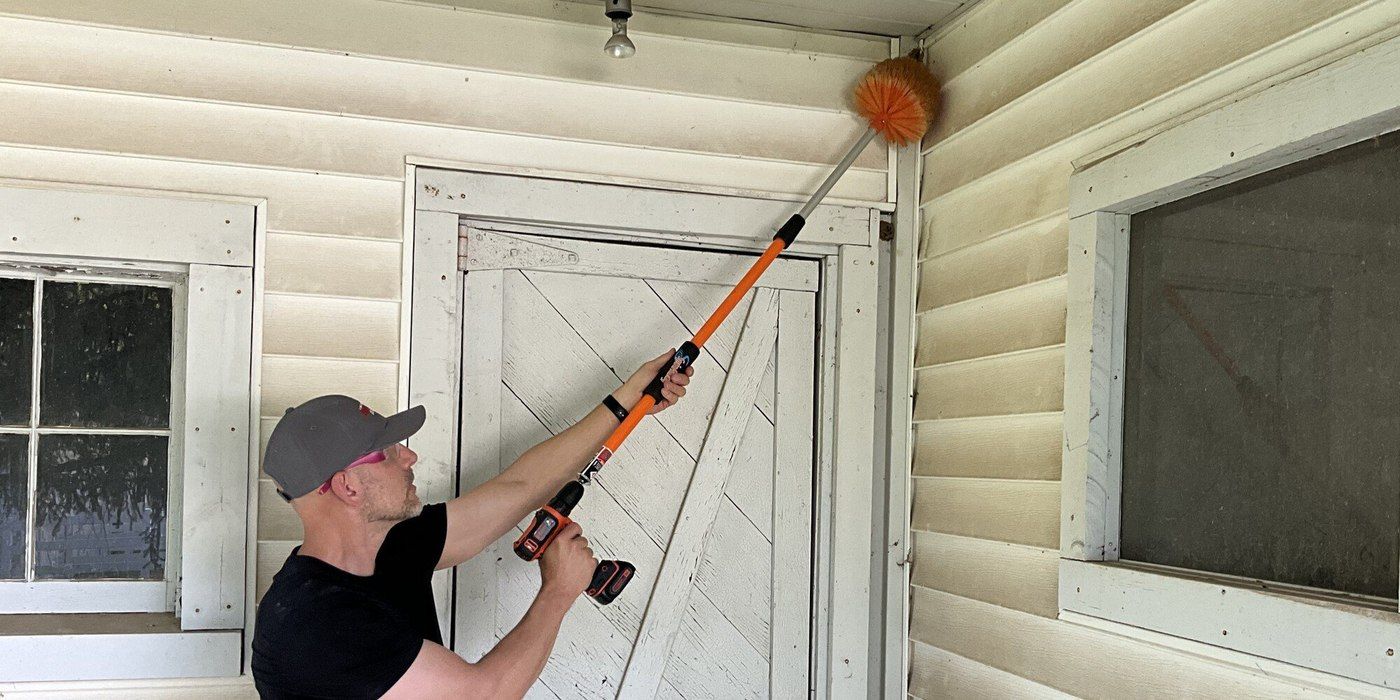 A man cleaning the corner of a door frame with the SpinAway rotary cleaning brush