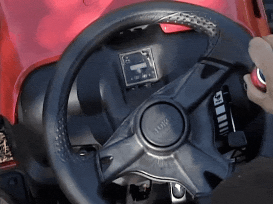 A GIF of a Good Vibrations Easy-Rider Tight-Turn Steering Knob installed on a Toro riding mower with a man using the knob to turn the wheel back and forth