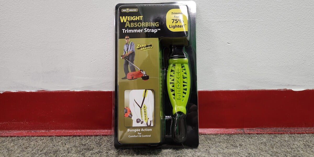 A Good Vibrations Zero Gravity Trimmer Shoulder Strap in its packaging leaning against a wall