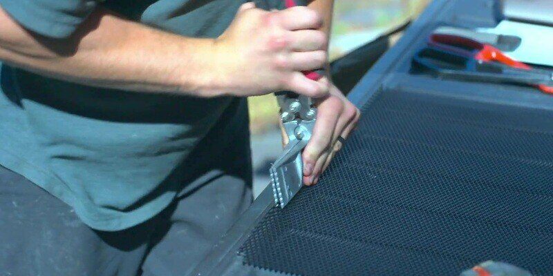 A man using a hand brake to bend the edges of a HY-GUARD EXCLUSION Pest Armor Tight Mesh Panel.