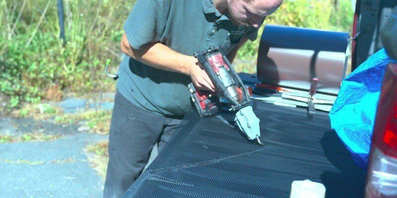 A man using powered sheet metal shears to cut a HY-GUARD EXCLUSION Pest Armor Tight Mesh Panel.