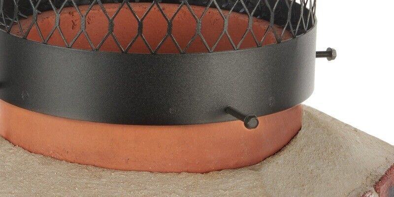 A close up of a Draft King Galvanized Steel Round Chimney Cap bolted onto a round flue tile.