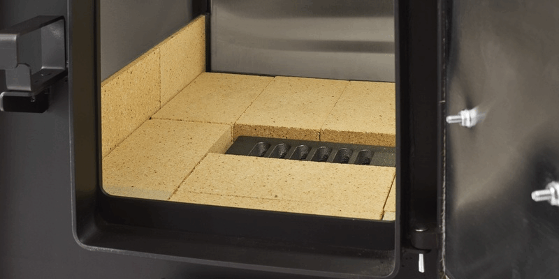 An image of the firebox of a Shelter SF1000E wood burning furnace. The firebrick which lines the firebox is visible.