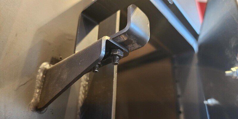 A picture of the underside of the door latch on a Fire Chief FC1000E model wood burning furnace.
