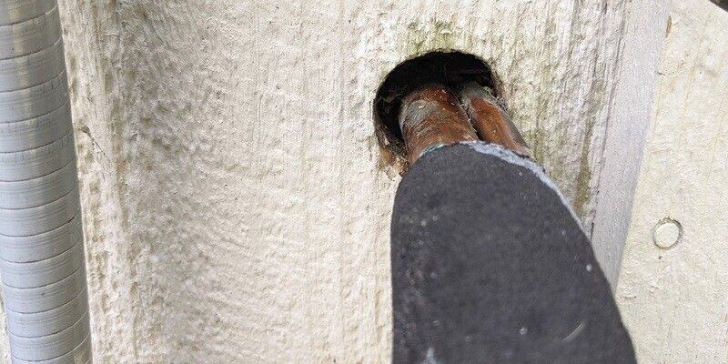 HVAC lines running into a hole in the side of a home. There is a gap between the HVAC line and the side of the hole.