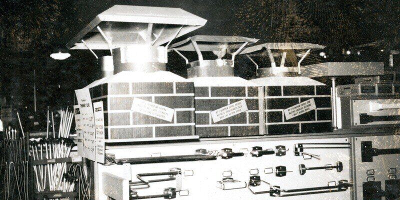 A black and white image (circa 1960) of HY-C chimney caps on mock masonry flues displayed in a hardware store.