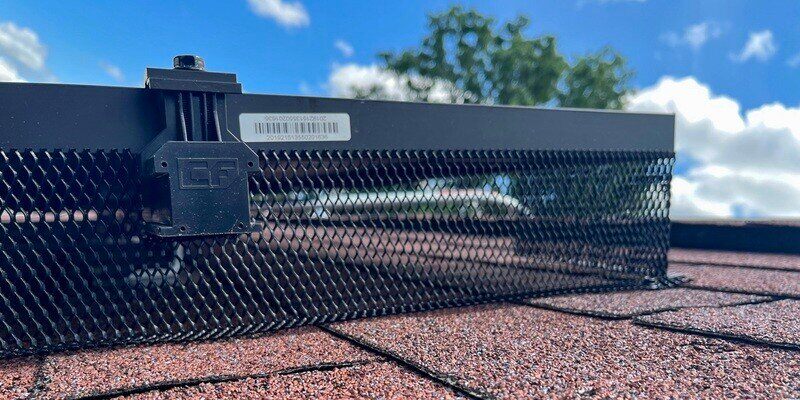 HY-GUARD EXCLUSION's L-Mesh Pest Armor installed on a solar panel on a roof with reddish shingles.