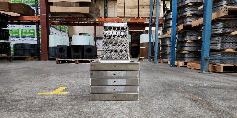 Five nine-by-nine Draft King Multi-Pack Stackable chimney cap sitting on the HY-C factory floor.