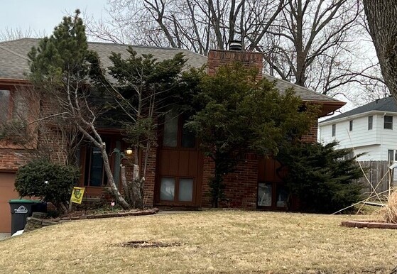 Image of home with overgrown evergreen shrubs