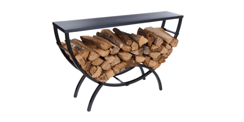 The five-feet-by-three-feet Shelter Crescent Firewood Rack with the optional Steel Tabletop resting on it. The rack is filled with logs.