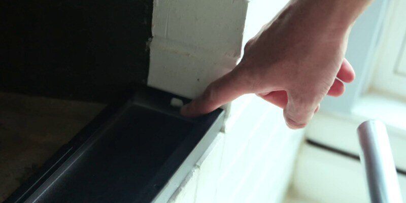 A hand pointing to the placeholder tab on the inside edge of a Liberty Foundry Co. Smoke Guard.