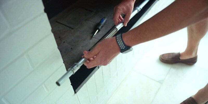 A man inserting the rods that hold tension in a Liberty Foundry Co. Smoke Guard.