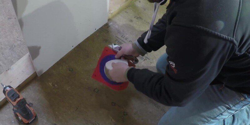 A man cutting out the innermost white circle of the SnugDryer stencil.