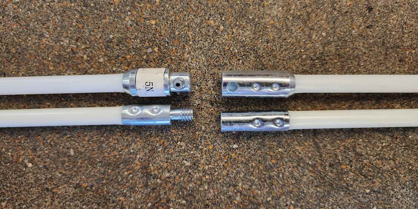 On top: disconnected button-link-style LintEater connector rods. On bottom: screw-on-style LintEater connector rods. All four rods are lying on a concrete floor.