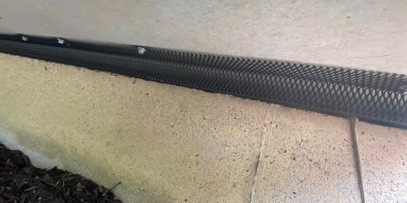A length of HY-GUARD EXCLUSION Pest Armor installed over a gap in the foundation of a building.