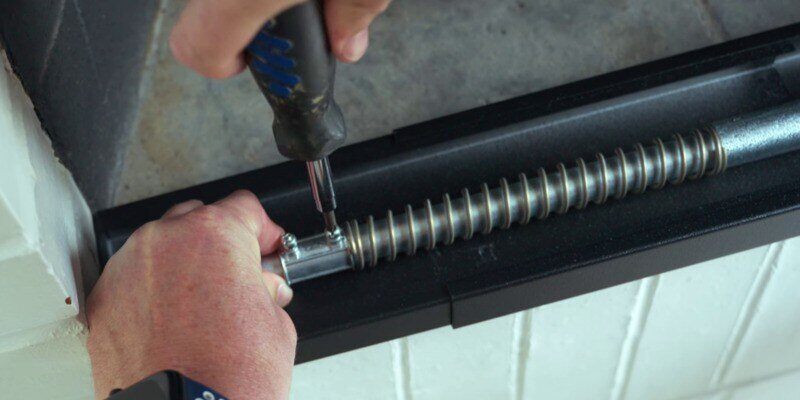 A man tightening the half-inch coupler of a Liberty Foundry Co. Smoke Guard in place to provide spring tension to the smoke guard.