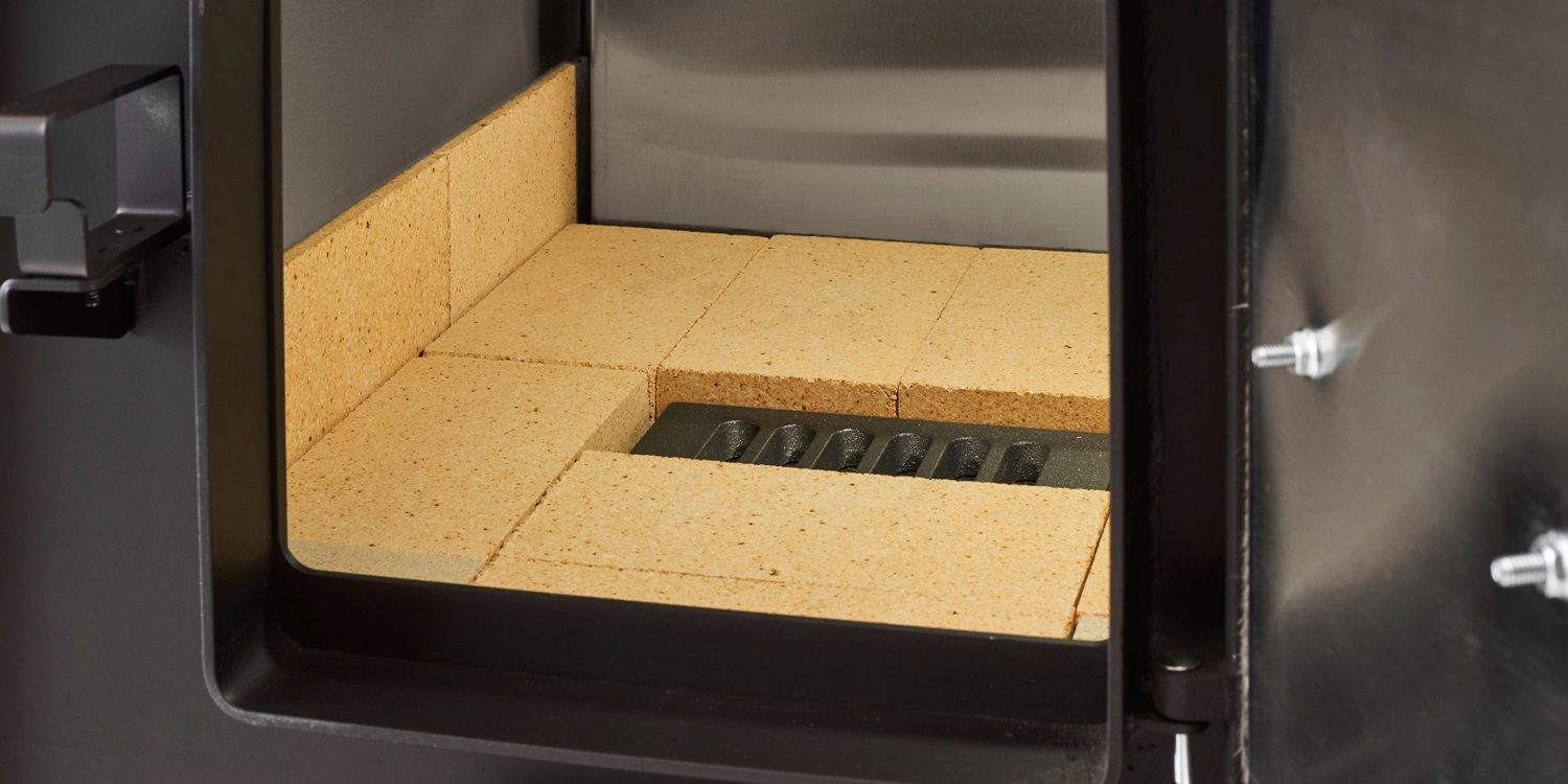The inside of a Fire Chief FC1000E wood burning furnace, showing firebrick lining the firebox.