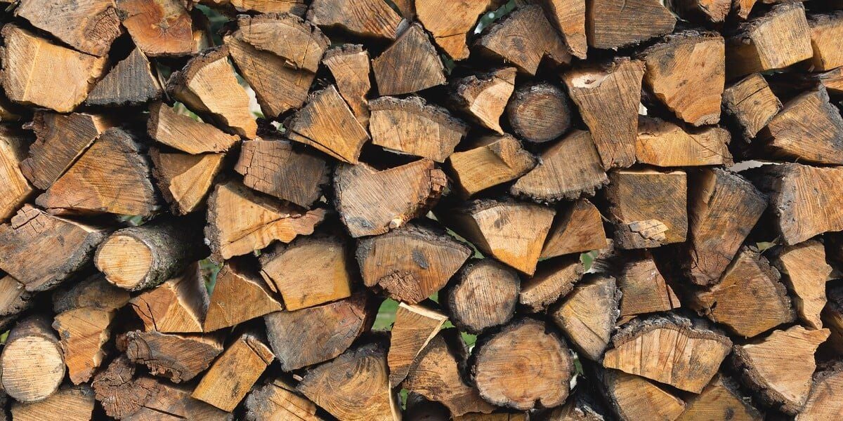 A close-up of a stack of seasoned, split firewood.