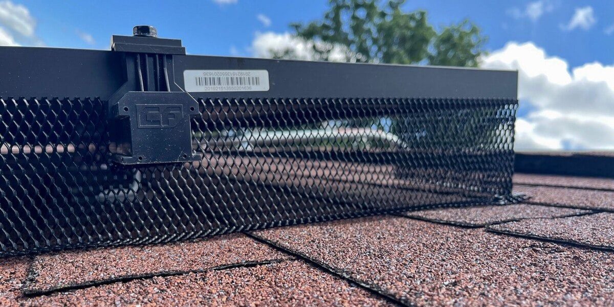 L-Mesh Pest Armor installed on a solar panel on a roof with brown shingles.